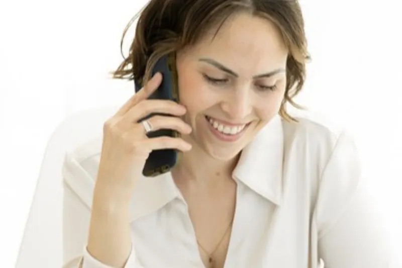 Jenna Phan smiling on a phone call at a bright desk, a free virtual sleep consultant discovery call
