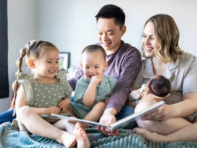 Calgary sleep consultant Jenna Phan with her husband and their three children reading a picture book together